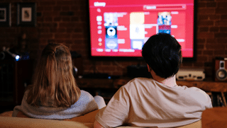 Couple watch movie streaming service in television